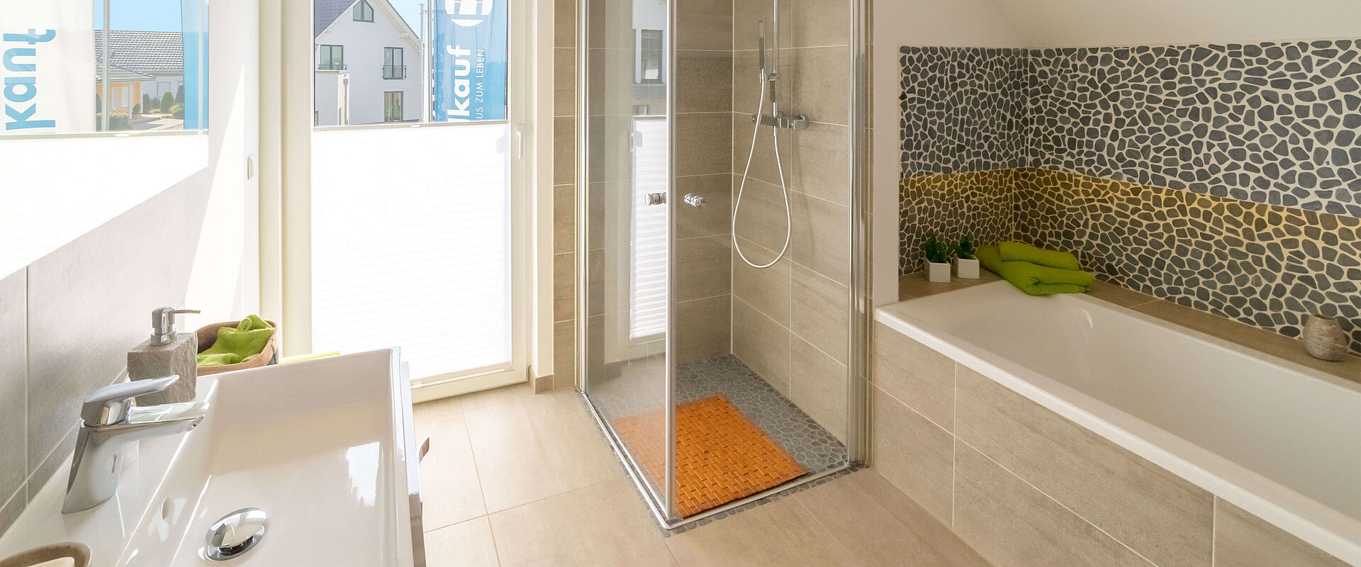 sandfarben gefliestes Bad, Wanne und ebenerdiger Dusche mit Akzentfließen in Mosaik-Optik